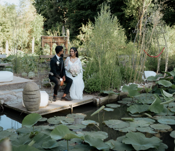 Evento elegante in una grande tensostruttura decorata con piante sospese, luci calde e ospiti che conversano attorno ai tavoli.